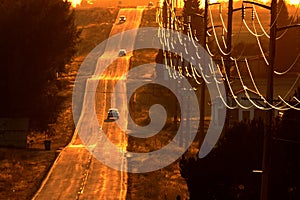 Cars Driving on County Road at Sunset or Sunrise