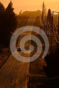 Cars Driving on County Road at Sunset or Sunrise