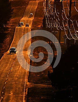 Cars Driving on County Road at Sunset or Sunrise