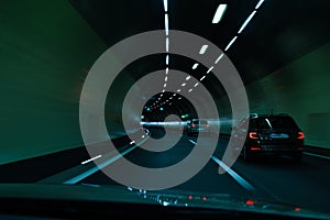 Cars driving fast through modern European tunnel. Switzerland