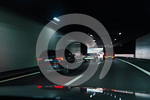 Cars driving fast through modern European tunnel. Switzerland