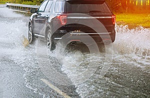 cars driving on a flooded road during a flood caused by heavy rain