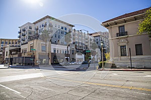 Cars driving and people walking at the corner of Colorado Blvd and Garfield Ave surrounded by apartments, office buildings