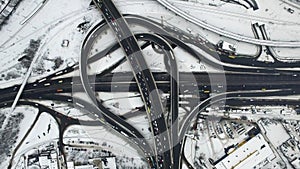 Cars driving on road interchange at winter. Top view snowy highway intersection