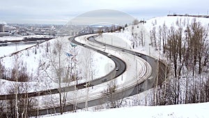 Cars driving on snowy road in winter, traffic driving along freeway highway