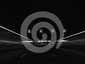 Cars driving through tunnel black and white image