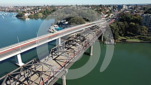 Cars driving on Victoria Road on the Iron Cove Bridge in Sydney, Australia over a calm sea