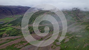 Cars Driving West Fjords Remote Road Hair Pin Turn Through Low Clouds and Lush Green Grass