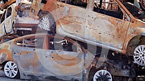 Cars after the fire. Iron parts of a burnt car. Burnt-out cars abandoned on the side of a quiet countryside. Explosion