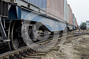 The cars of a freight train stretching into the distance with tanks of a different composition from a distance