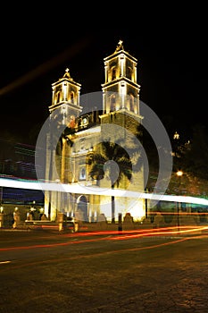 Cars going by Cathedral of San Gervasio in Valladolid, Mexico photo