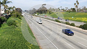 Cars on interstate highway California USA. Intercity freeway transport. Road traffic and greenery.