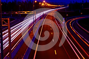 Cars light trails on a curved highway at night. Night traffic trails. Motion blur. Night city road with traffic headlight motion.