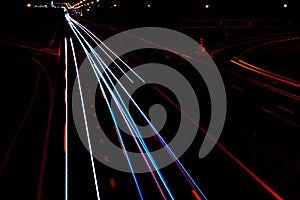 Cars light trails on a curved highway at night. Night traffic trails. Motion blur. Night city road with traffic headlight motion.