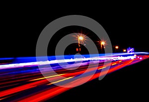 Cars light trails on a curved highway at night. Night traffic trails. Motion blur. Night city road with traffic headlight motion.