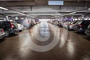 Cars are on multistorey parking lot, all places are occupied, red lights above vehicles