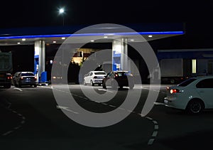 Cars at night at a gas station in summer
