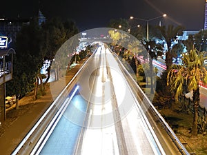 Cars at night on  highway rope lights and illuminated signs