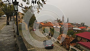 Cars on old cobblestone street with private houses in Georgian Sighnaghi town