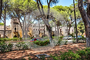 Cars parked in front of deserted building of sanatorium in Italian village of Eleousa Rhodes, Greece