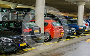 Cars parked in a indoor parking garage, long row of cars, commercial parking lot