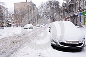 Cars parked on a street covered with snow. After blizzard, Kyiv, Ukraine