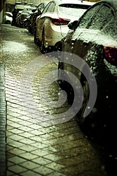 Cars parked on the street while it snows