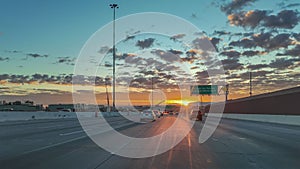 cars are parked in traffic on the highway at sunset with signs