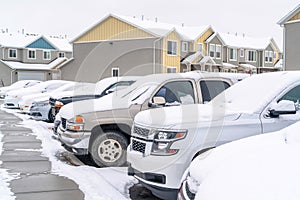 Cars in the parking lot of a neighborhood against homes and apartments in winter