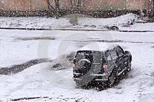 The cars on the parking under snow .