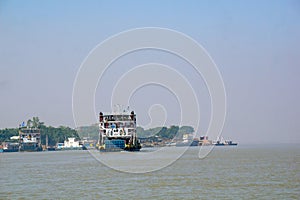 Cars and people are crossing from one side of the padma river to the other by ferry