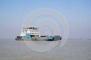 Cars and people are crossing from one side of the padma river to the other by ferry