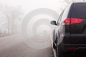 Cars on the road in the fog. Bad winter weather and dangerous automobile traffic on the road. Light vehicles in fog. Foggy gray