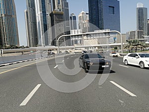 Cars in road and skyscrapers in background
