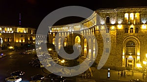 Cars slowly driving through night Republic square in Yerevan, lights in city