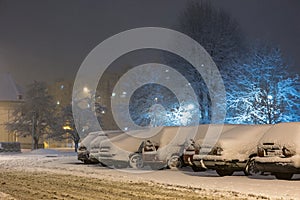 Cars in snow after snowstorm in night, winter photography and snow calamity