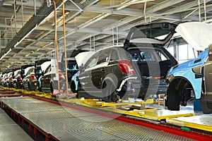 Cars stand on the conveyor line of assembly shop. Automobile pro