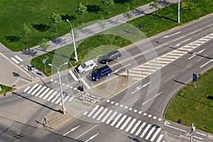 Cars standing in front of crosswalk on crossroad, aerial view