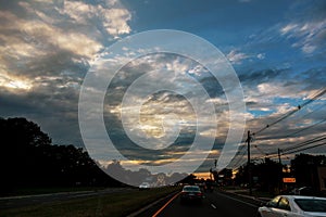 Cars in traffic at anlights on a busy highway sunset evening