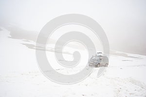 Cars of travelers on mountain snow road landscape. 4x4 jeep car on a mountain pass, mount peak.