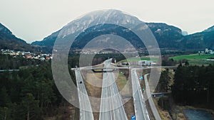 Cars Traverse the Road Amidst the Swiss Mountains through Motorways and Crossroads.