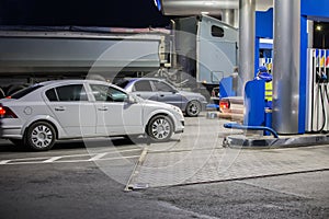 Cars and truck at night at lighted gas station