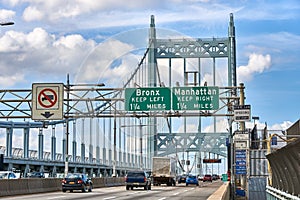 Cars and trucks on the Robert F Kennedy Bridge, with signs for exits to the Bronx and Manhattan
