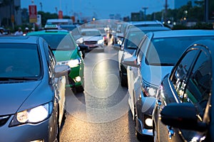 Cars on urban street in traffic jam at twilight