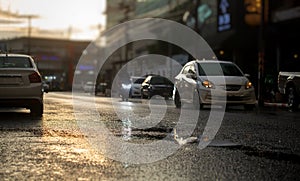 Cars on wet road after hard rain fall with evening light in the city.