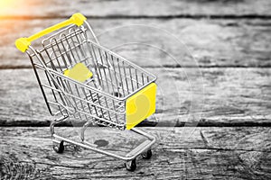 Cart from the grocery store on the old wooden background. Empty shopping trolley.