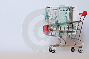 Cart from the supermarket filled with Russian paper rubles. Purchasing power, economy and exchange rate. Pension and social