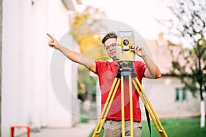 Cartographer engineer, surveyor working with total station construction site elevation photo