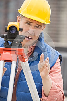 Cartographer Gesturing While Using Theodolite
