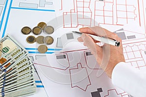 Cartographer with money drawing cadastral map photo